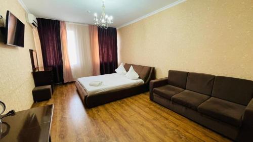 a living room with a couch and a couch and a bed at ALCAZAR in Atyrau