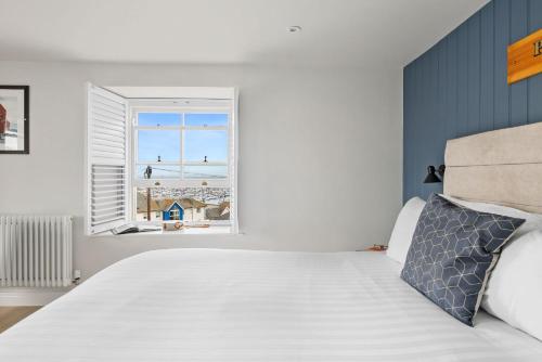 a bedroom with a bed and a window at Pilgrim Suite - Sea View - Free Wi-Fi in Brixham