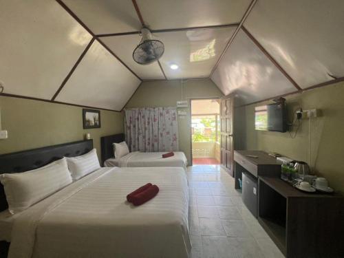a bedroom with two beds and a desk and a television at Delta Chenang Resort in Pantai Cenang