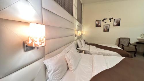 a bedroom with two beds with white sheets at Adams Lodge F-7 in Islamabad