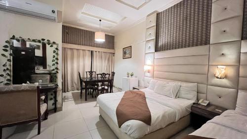 a bedroom with a bed and a dining room at Adams Lodge F-7 in Islamabad