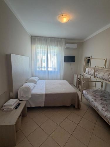 a bedroom with a bed and a window and a couch at Terme Palace Hotel in Montecatini Terme