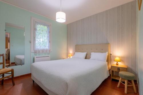 a bedroom with a large white bed and a window at Gîte Le Mazet Des Campanes in Saint Alban Auriolles