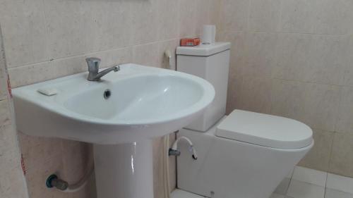 a bathroom with a white sink and a toilet at Wild View Stay in Habarana