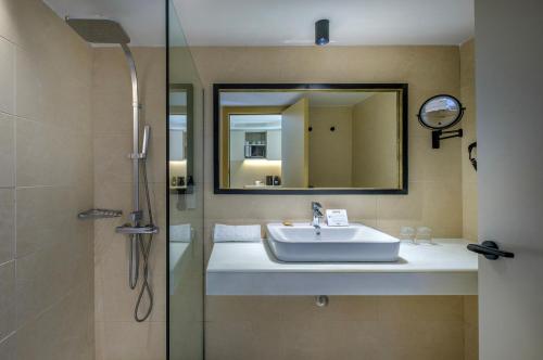 a bathroom with a sink and a shower and a mirror at Cabot Cap de Mar Spa in Cala Bona