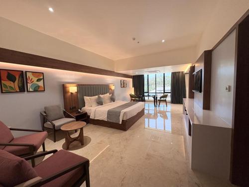 a hotel room with a bed and a living room at Omkar Jungle Resort & Spa, Sirsi in Islūr