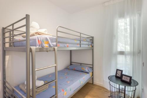 a bedroom with two bunk beds with blue sheets at Myholidayshome in Palamós