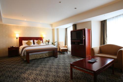 International Resort Hotel Yurakujo في ناريتا: غرفة فندق بسرير وتلفزيون