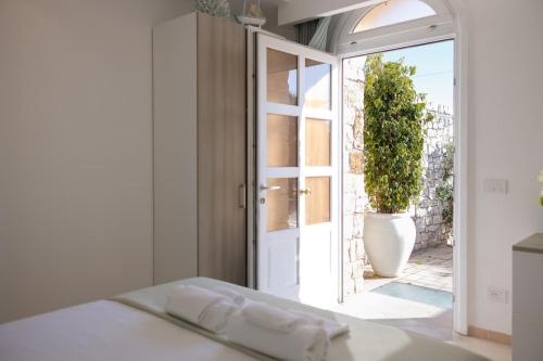 a bedroom with a door and a vase with a plant at Fronte Mare Polignano a Mare in Polignano a Mare