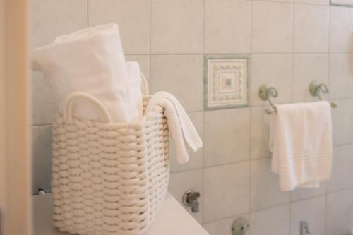a bathroom with a basket of towels on a sink at Fronte Mare Polignano a Mare in Polignano a Mare