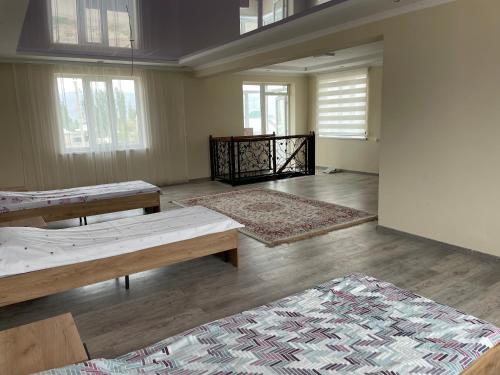 an empty room with two beds and two rugs at Zhailoo Guest House Kochkor in Kochkorka