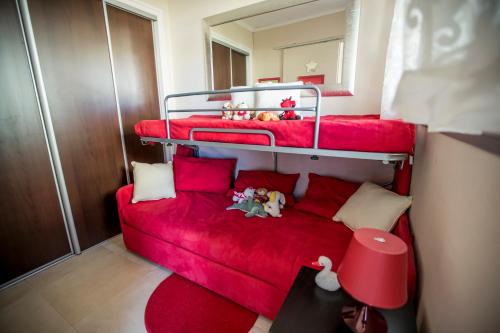 a living room with a red couch and bunk beds at Eden by Connexion in Cannes