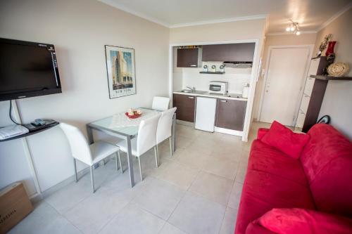 un salon avec un canapé rouge et une table dans l'établissement Eden by Connexion, à Cannes