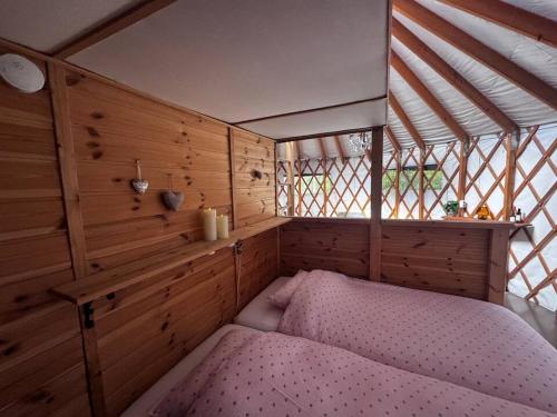 a bedroom with a bed in a room with wooden walls at Halvorseth in Prestfoss