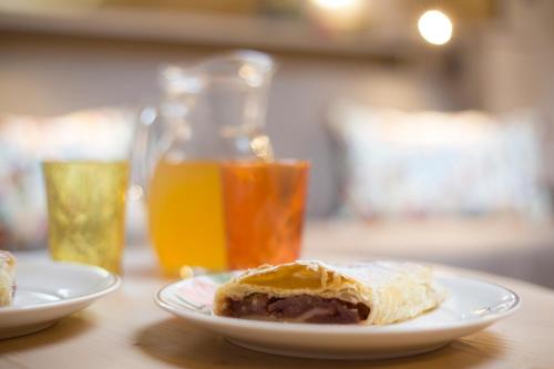 a plate with a pastry on a table with orange juice at Bio Agritur Le Millemele in Spormaggiore