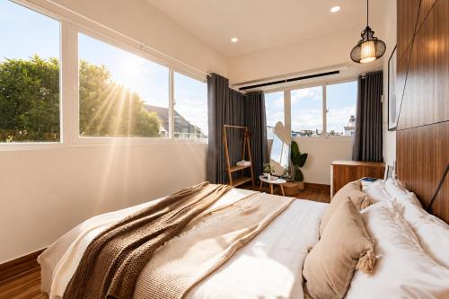 a bedroom with a bed and a large window at The Morris City Central Boutique in Da Lat