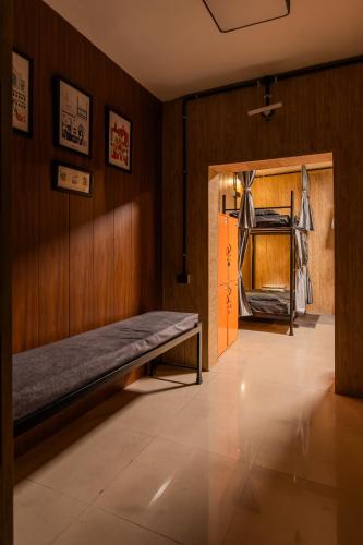 a room with a bench on a wall and a door at Ghumakkads Hostel Near IGI Airport & Aerocity in New Delhi
