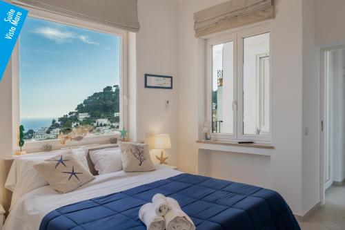 a bedroom with a bed with a large window at Casa Leucosia Suites in Capri
