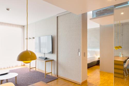 a living room with a table and a bed at Factory Hotel in Münster