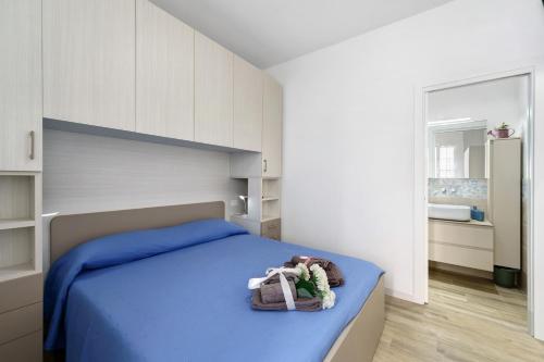 a bedroom with a bed with blue sheets and white cabinets at Il Timone e L'Ulivo in Moneglia