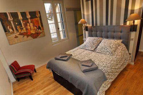 une chambre avec un lit et une chaise rouge dans l'établissement Le Loft Exceptionnel, à Sarlat-la-Canéda