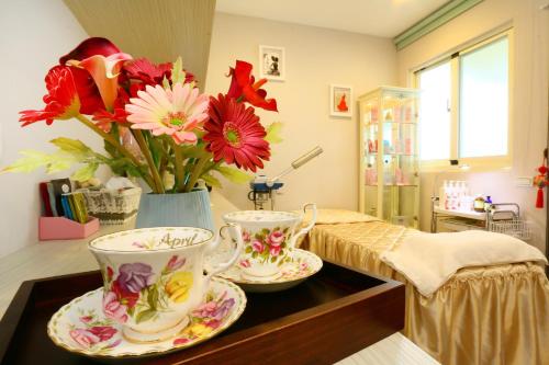 two tea cups and saucers on a table with flowers at Creekside No.22 B&B in Jiali