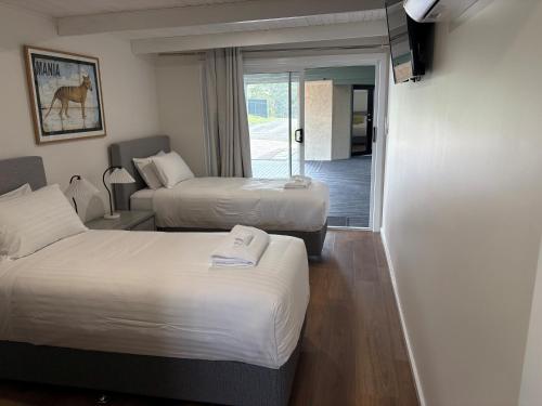 a hotel room with two beds and a balcony at the Lodge farm house in Hindmarsh Valley