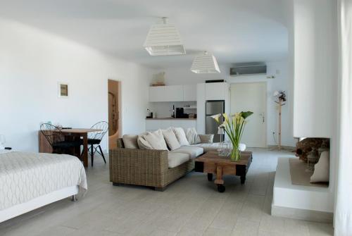 a white living room with a couch and a table at Chrysalis Nature Villa 8 in Kampos Paros