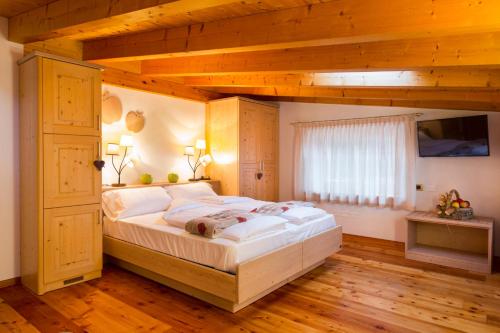 スポルマッジョーレにあるBio Agritur Le Millemeleの木製の天井のベッドルームの大型ベッド1台