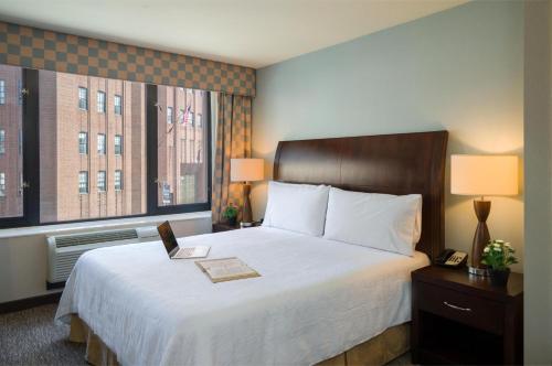 a hotel room with a bed and two windows at AMTD Idea Tribeca Hotel in New York