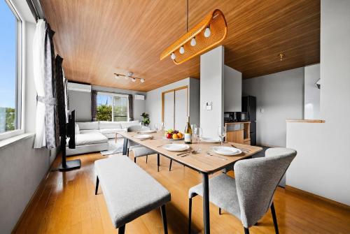 a dining room and living room with a table and chairs at Silvale in Kami-furano