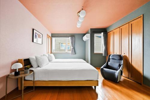 a bedroom with a bed and a chair at Silvale in Kami-furano