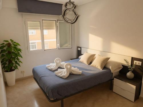 a bedroom with a bed with two towels on it at Piso Almería playa in Almería