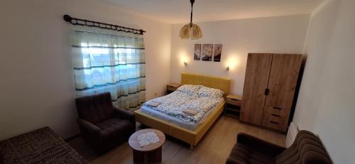 a small bedroom with a bed and a chair at Gergócs Vendégház in Őriszentpéter