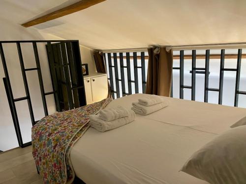 ein Schlafzimmer mit einem Bett, auf dem zwei Handtücher liegen in der Unterkunft Duplex studio Moulleau proche plage avec chambre en mezzanine in Arcachon