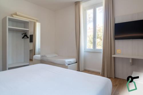 a bedroom with a white bed and a window at Hotiday Castiglioncello Suite in Castiglioncello