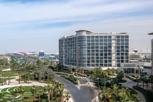 a tall building in a city with palm trees at Yas Plaza Marina by IHG in Abu Dhabi