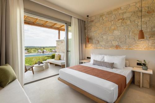 a bedroom with a bed and a stone wall at TERTH - Afytos Experience in Afitos