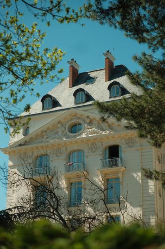 a large white building with windows and a roof at Waldorf Astoria Versailles - Trianon Palace in Versailles