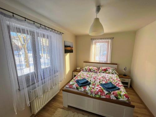a bedroom with a bed and a large window at Wieś odNowa in Krynica Zdrój