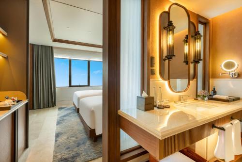 a bathroom with a sink and a bed in a room at Grand Hotel De Djokja in Yogyakarta