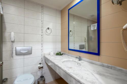 a bathroom with a sink and a mirror and a toilet at Solivia hotel in Alanya