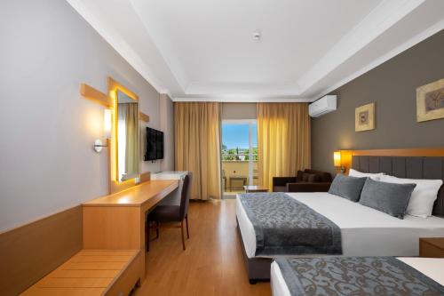 a hotel room with two beds and a desk at Solivia hotel in Alanya