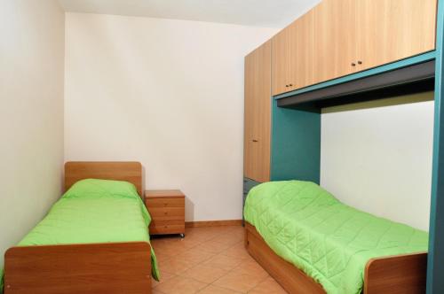 sypialnia z 2 łóżkami i zieloną pościelą w obiekcie Residenza San Rocco w Asti