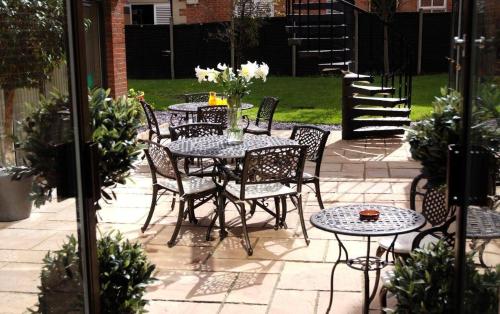 a patio with a table and chairs and flowers at Hermitage Park Hotel in Coalville