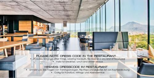 a restaurant with tables and chairs and windows at COOL MAMA Hotel Salzburg in Salzburg