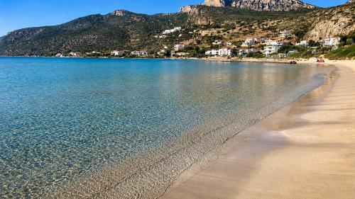 a beach with houses and mountains in the background at Seaside Plitra Paradiso - Steps from the Beach in Plytra