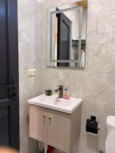 a bathroom with a white sink and a mirror at Villa Kapreshumi in Itʼkhvisi