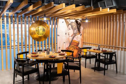 a restaurant with tables and chairs and a painting on the wall at Citymax Sharjah in Sharjah