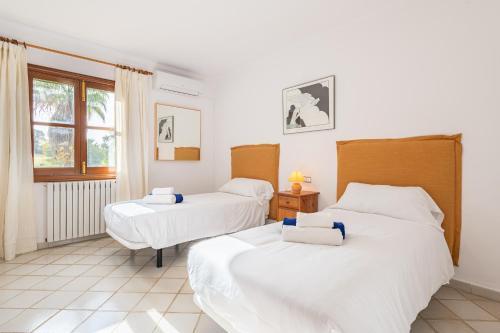 a bedroom with two beds and a window at Finca Binifarda by Mallorca House Rent in Felanitx